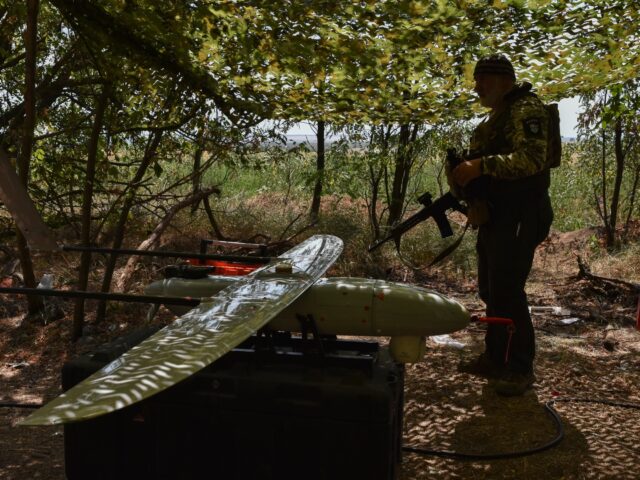 A soldier of Ukraine's National Guard 15th Brigade stands by a reconnaissance drone Pengui