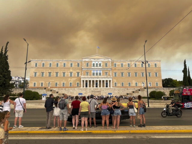 Smoke from wildfires is seen above the Greek parliament building in central Athens, Sunday