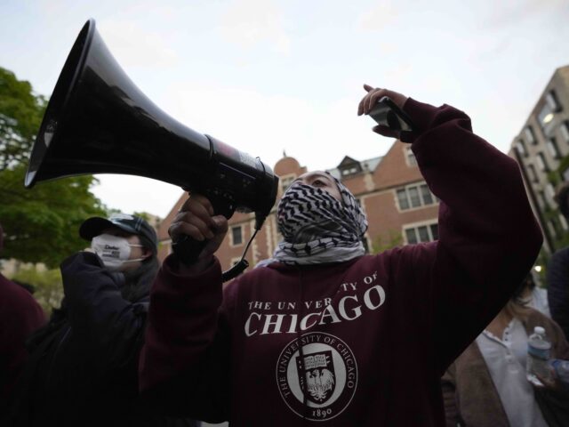 A pro-Palestinian protester leads chants at the university's police as they are kept