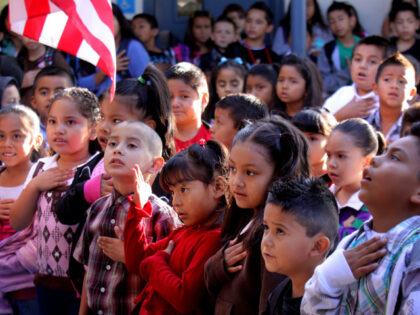 Hispanic school children recite the Pledge of Allegiance before class at Felicita Elementa