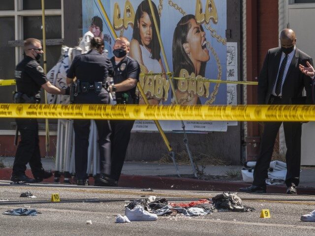 A photographer with the Los Angeles Police Department, far right, documents the remains of