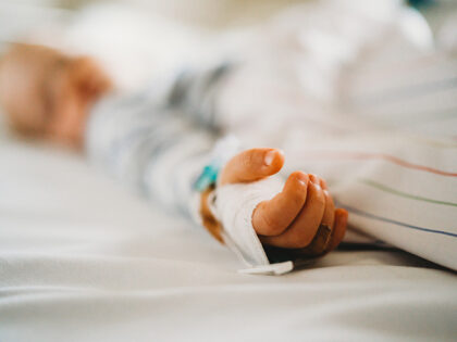 Baby child hand with IV sick at the hospital with a virus coronavirus - stock photo