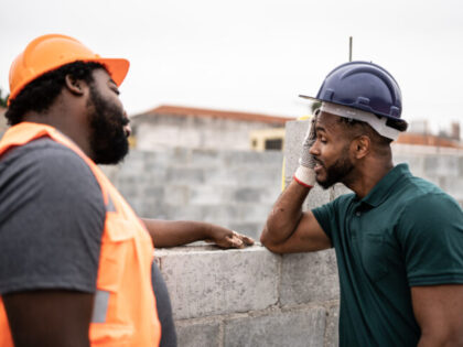 Worried coworkers talking in a construction site