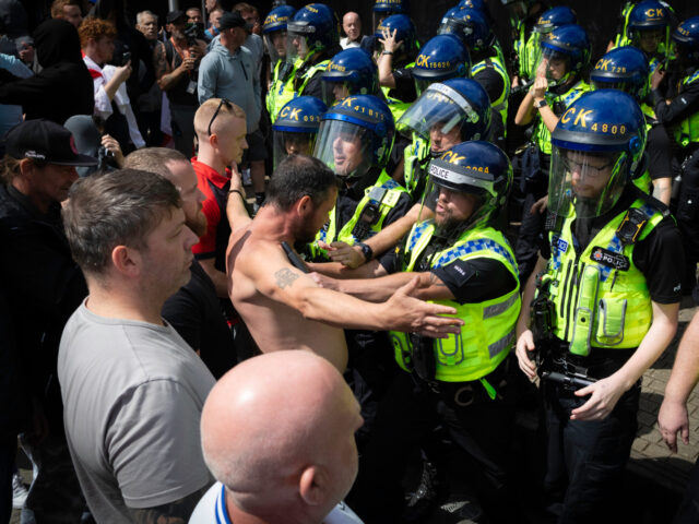 MANCHESTER, UNITED KINGDOM - 2024/08/03: An anti-immigration supporter confronts riot poli