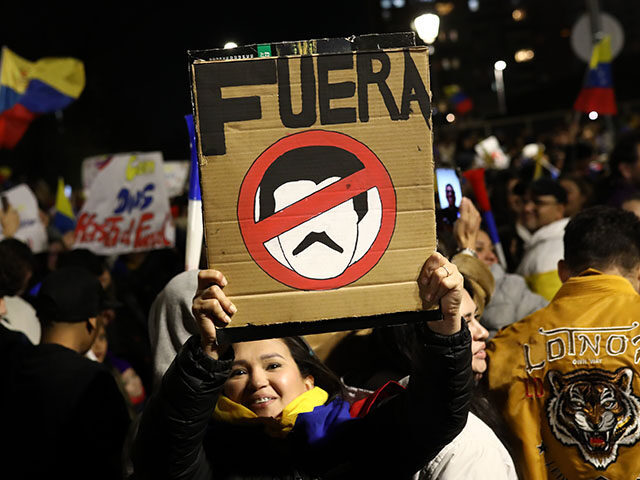 A woman holds a banner reading 'Fuera' in Spanish as Venezuelan expatriates protest the re