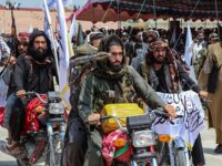 Taliban security personnel holding rocket-propelled grenade (RPGs) ride motorbikes as they