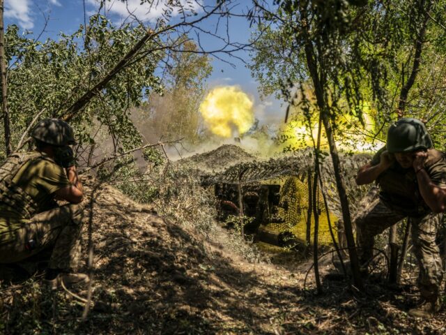 DONETSK OBLAST, UKRAINE - JULY 29: Ukrainian soldiers firing with D30 artillery at their f