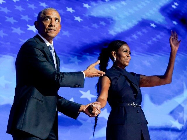 Former US President Barack Obama, left, arrives to speak next to former US First Lady Mich