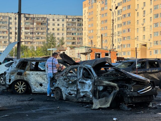 SUMY, UKRAINE - AUGUST 17: A man stands next to the burnt wreckage of cars in a residentia