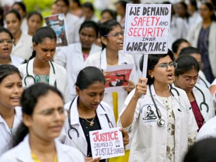 Doctors hold posters to protest the rape and murder of a young medic from Kolkata, at the