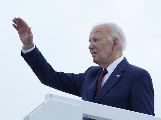 President Joe Biden waves from the top of the steps of Air Force One at Joint Base Andrews