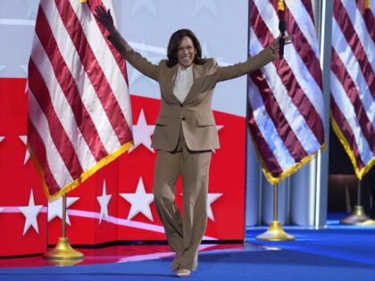 Democratic presidential nominee Vice President Kamala Harris raises her arms as she walks