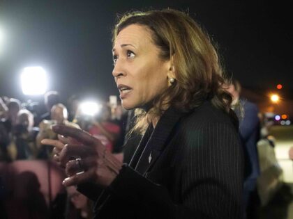 Vice President Kamala Harris speaks with reporters after greeting reporter Evan Gershkovic