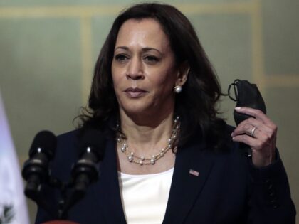 Vice President Kamala Harris removes her mask, amid the COVID-19 pandemic, at the start of