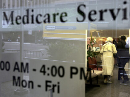 Two people walk inside a Medicare Services office on the last day for enrollment in the Me