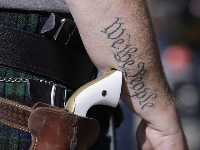 FILE - In this Jan. 26, 2015 file photo, a supporter of open carry gun laws, wears a pisto