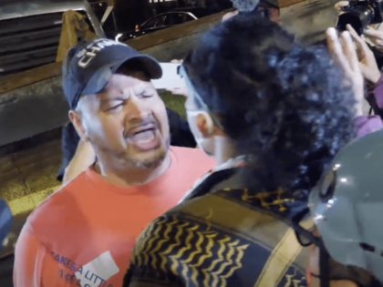 A driver confronts a protester who tried to obstruct his car outside the Democratic Nation