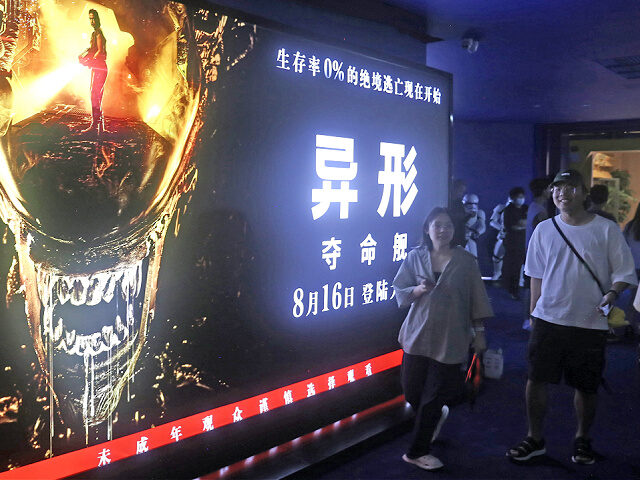 SHANGHAI, CHINA - AUGUST 13, 2024 - Fans walk past a promotional poster inside the Hollywo