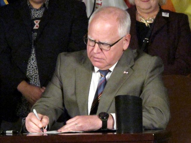 Minnesota Gov. Tim Walz signs a ban on so-called conversion therapy during a ceremony at t