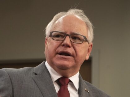 Gov. Tim Walz gestures at a presentation during news conference inside the Department of P