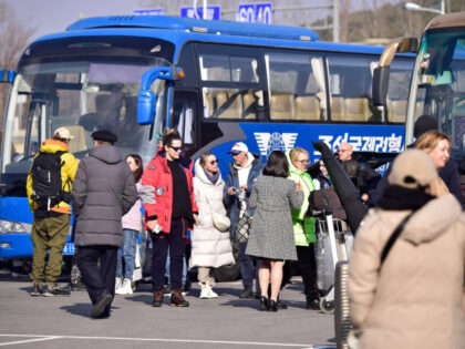 A group of Russian tourists prepare to board coaches after they arrived at Pyongyang Inter