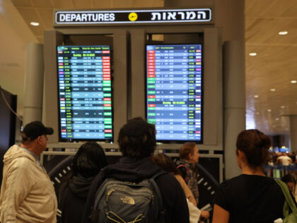 Passengers look at a departure board at Ben Gurion Airport near Tel Aviv, Israel, on Octob