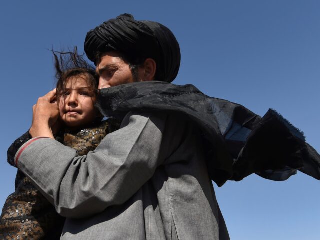 Abdul Haq (right) holds his 4 year old daughter Khadija (left) in Regreshan camp for the i