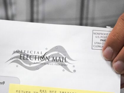 An election worker holds an election envelope during a tour of Utah County's election