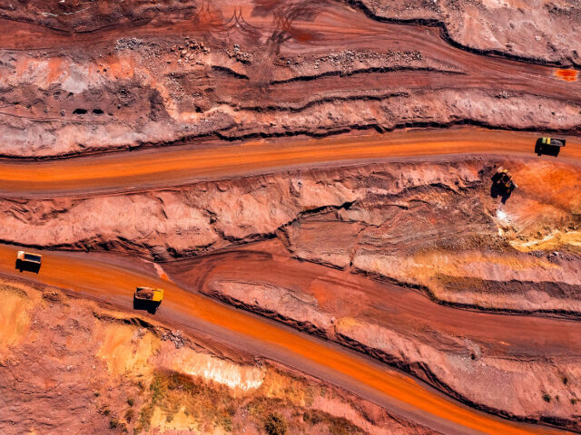 Aerial view of open pit iron ore and heavy mining equipment. - stock photo