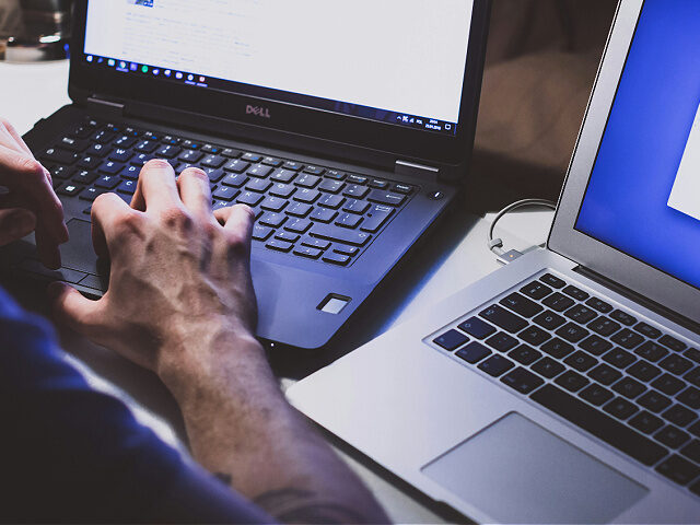 person using multiple laptops