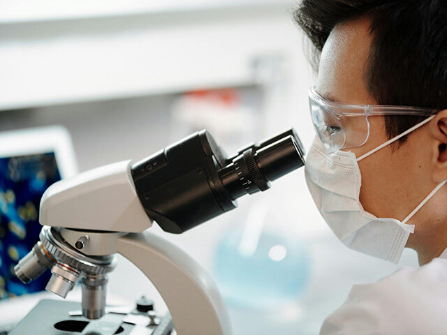 Man Looking Through A Microscope