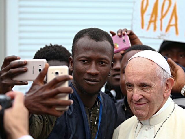 Pope Francis poses for a selfie with a man as he visits a migrant reception centre during