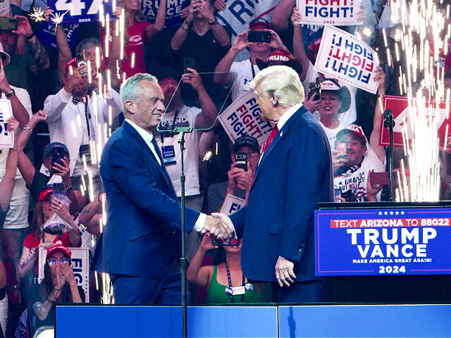 Former US President and Republican presidential candidate Donald Trump (R) shakes hands wi