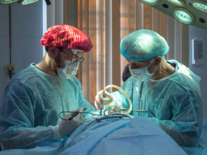 two men wearing blue lab coats