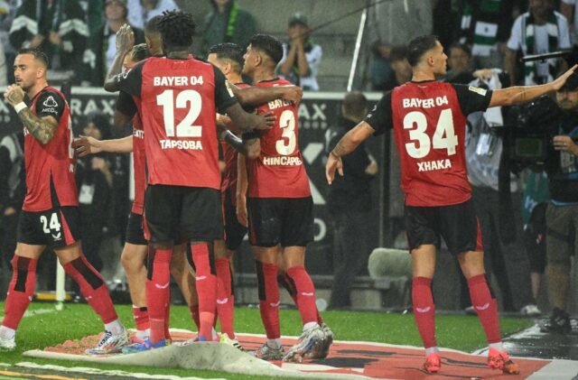 Bayer Leverkusen players celebrate their last-gasp winner at Borussia Moenchengladbach