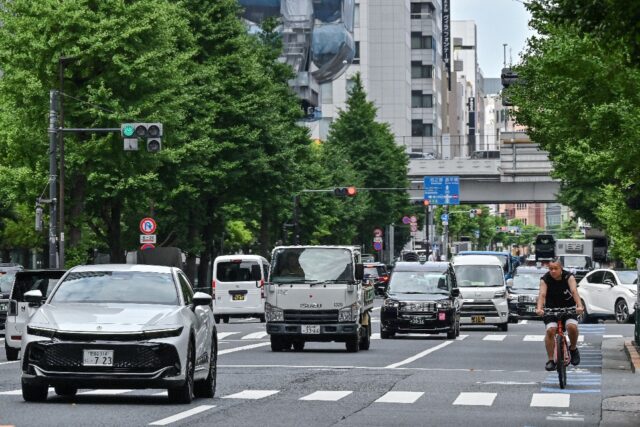 A cyclist navigates through traffic in the business district of Otemachi in central Tokyo.