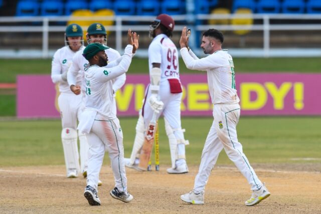 Keshav Maharaj (R) celebrates the dismissal of Keacy Carty (C) during day three of the fir