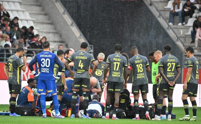 Lille players surround Angel Gomes after he suffered a serious head injury against Reims i