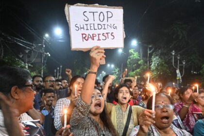 Marchers hold posters and candles at a midnight protest in Kolkata on August 14 to condemn