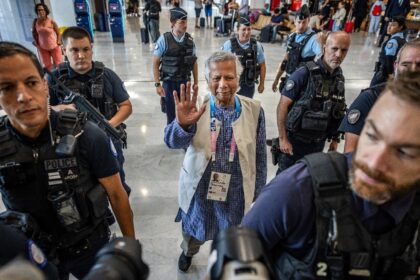 Nobel peace prize winner Muhammad Yunus (C) at Paris' main airport before flying back to f