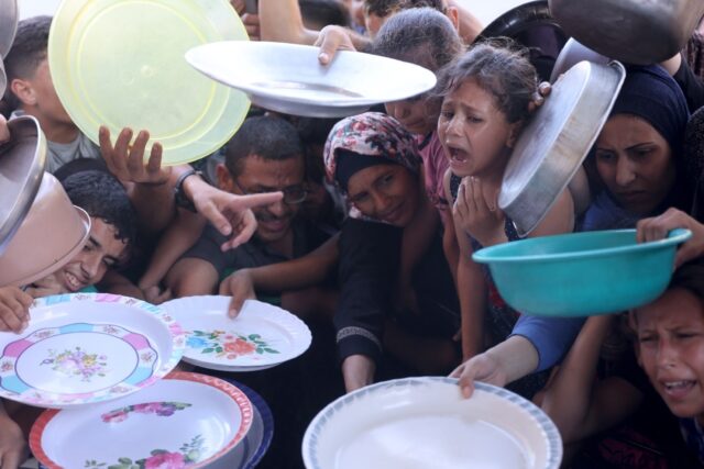 Palestinian children throng a food distribution centre in Gaza to get a free meal as exper