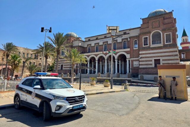 Police officers stand guard outside Libya's central bank headquarters in Tripoli