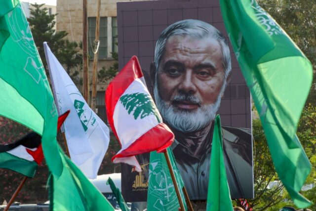 A portrait of slain Hamas political leader Ismail Haniyeh provides a backdrop to a demonst