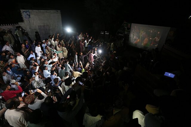 Relatives and supporters of Pakistan athlete Arshad Nadeem watch the javelin event at a vi