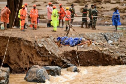 Rescuers retrieve the body of one of the more than 200 people killed in landslides trigger