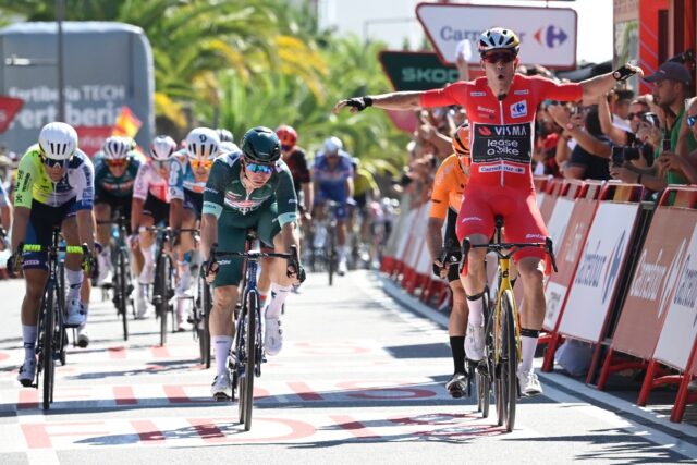 Visma's Wout van Aert (R) celebrates as he crosses the finish winning stage three of the V