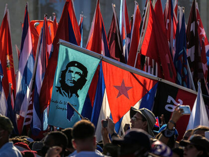 Cubans file past waving national flags and flags with the image of revolution hero Ernesto