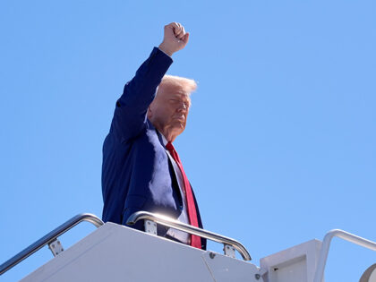 Republican presidential nominee former President Donald Trump gestures as he boards a plan