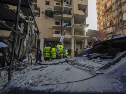 Rescuers check a building that was hit by an Israeli airstrike in Beirut's southern s