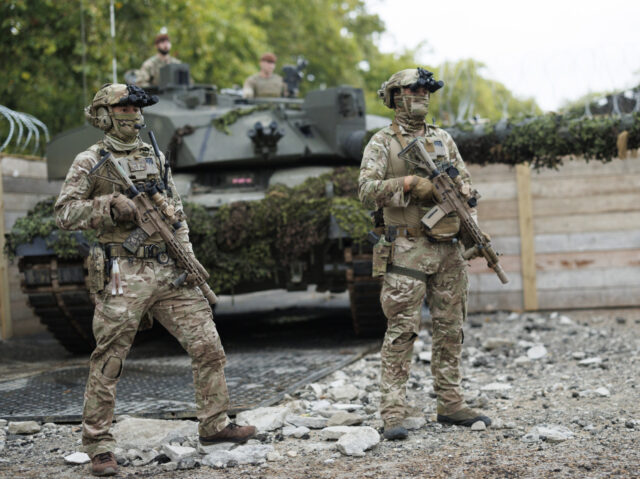 Members of the British Army are seen here with a Challenger 2 Main Battle Tank in the back